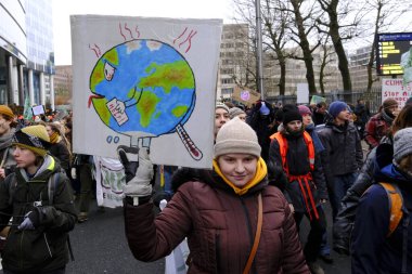 Bir gösterici, COP28 'in 3 Aralık 2023' te Brüksel, Belçika 'da Dubai' de düzenlenen bir iklim protestosu sırasında bir pankart tutuyor..