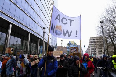 İnsanlar, COP28 'in 3 Aralık 2023' te Brüksel, Belçika 'da Dubai' de düzenlenen bir iklim protestosuna katılıyor..