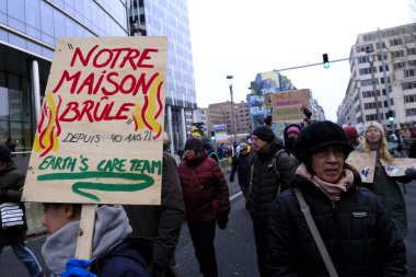 Bir gösterici, COP28 'in 3 Aralık 2023' te Brüksel, Belçika 'da Dubai' de düzenlenen bir iklim protestosu sırasında bir pankart tutuyor..