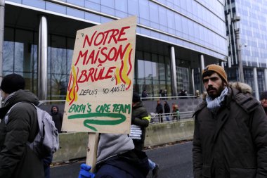 Bir gösterici, COP28 'in 3 Aralık 2023' te Brüksel, Belçika 'da Dubai' de düzenlenen bir iklim protestosu sırasında bir pankart tutuyor..