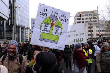 Bir gösterici, COP28 'in 3 Aralık 2023' te Brüksel, Belçika 'da Dubai' de düzenlenen bir iklim protestosu sırasında bir pankart tutuyor..