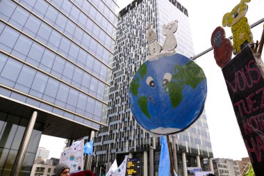 Bir gösterici, COP28 'in 3 Aralık 2023' te Brüksel, Belçika 'da Dubai' de düzenlenen bir iklim protestosu sırasında bir pankart tutuyor..