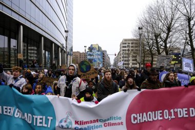 İnsanlar, COP28 'in 3 Aralık 2023' te Brüksel, Belçika 'da Dubai' de düzenlenen bir iklim protestosuna katılıyor..