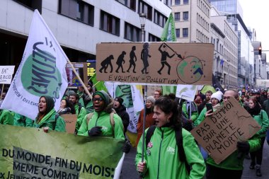 Bir gösterici, COP28 'in 3 Aralık 2023' te Brüksel, Belçika 'da Dubai' de düzenlenen bir iklim protestosu sırasında bir pankart tutuyor..