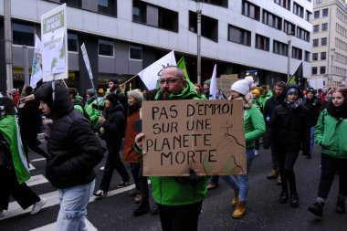 Bir gösterici, COP28 'in 3 Aralık 2023' te Brüksel, Belçika 'da Dubai' de düzenlenen bir iklim protestosu sırasında bir pankart tutuyor..