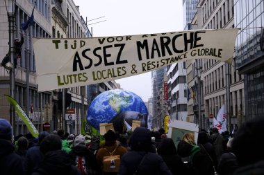İnsanlar, COP28 'in 3 Aralık 2023' te Brüksel, Belçika 'da Dubai' de düzenlenen bir iklim protestosuna katılıyor..