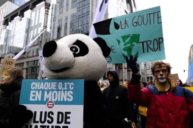 İnsanlar, COP28 'in 3 Aralık 2023' te Brüksel, Belçika 'da Dubai' de düzenlenen bir iklim protestosuna katılıyor..