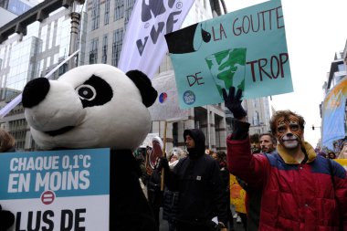 İnsanlar, COP28 'in 3 Aralık 2023' te Brüksel, Belçika 'da Dubai' de düzenlenen bir iklim protestosuna katılıyor..