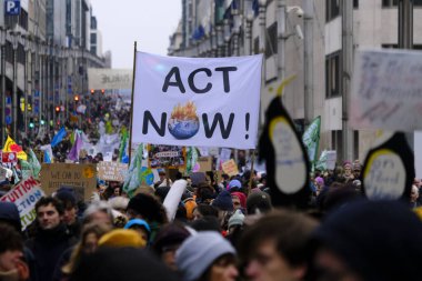 İnsanlar, COP28 'in 3 Aralık 2023' te Brüksel, Belçika 'da Dubai' de düzenlenen bir iklim protestosuna katılıyor..