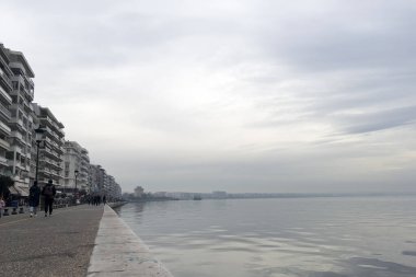 Yunanistan 'ın kuzeyindeki Selanik kentinde 3 Ocak 2024' te deniz kenarında sisli bir günde yayalar yürüyor