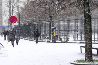 17 Ocak 2024 'te Brüksel' in merkezinde yoğun kar yağışı sırasında insanlar yürür.