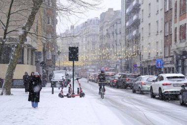 17 Ocak 2024 'te Brüksel' de yoğun kar yağışı sonrasında kar altında yola çıkan bir bisikletçi,.