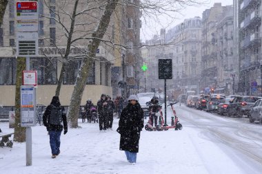 17 Ocak 2024 'te Brüksel' in merkezinde yoğun kar yağışı sırasında insanlar yürür.