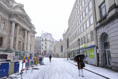 17 Ocak 2024 'te Brüksel' in merkezinde yoğun kar yağışı sırasında insanlar yürür.
