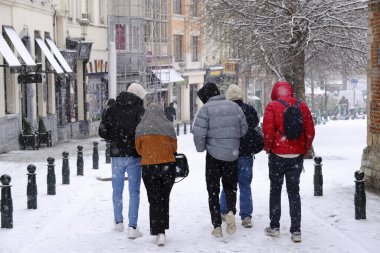 17 Ocak 2024 'te Brüksel' in merkezinde yoğun kar yağışı sırasında insanlar yürür.