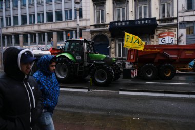 26 Şubat 2024 'te Brüksel, Belçika' da çiftçilerin fiyat baskıları, vergiler ve yeşil yönetmelik protestoları sırasında traktörlerin önünde yürüyen yayalar.