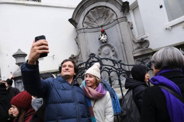 Turistler, Belçika 'nın Brüksel kentindeki Helenik Topluluğun 80. yıldönümünü kutlamak için 24 Şubat 2024' te Evzone kostümü giyen ünlü çeşme heykeli Manneken Pi 'yi ziyaret ettiler.. 