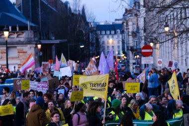 Uluslararası Kadın Günü münasebetiyle 8 Mart 2024 'te Brüksel, Belçika' da düzenlenen gösteride göstericiler pankart tutuyor ve sloganlar atıyorlar.