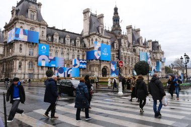 İnsanlar 29 Mart 2024 'te Paris' teki belediye binasının önünde yürüyorlar..