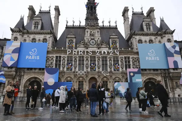 İnsanlar 29 Mart 2024 'te Paris' teki belediye binasının önünde yürüyorlar..