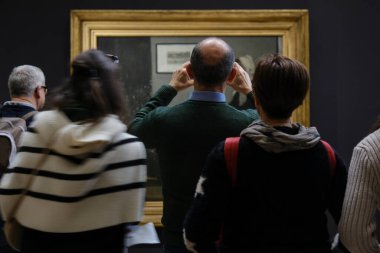 Ziyaretçiler, 30 Mart 2024 'te Paris, Fransa' daki Orsay Müzesi 'ndeki sanatçıların resimlerine bakıyorlar.