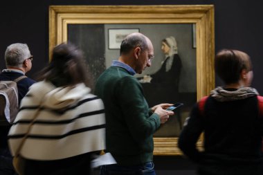 Ziyaretçiler, 30 Mart 2024 'te Paris, Fransa' daki Orsay Müzesi 'ndeki sanatçıların resimlerine bakıyorlar.