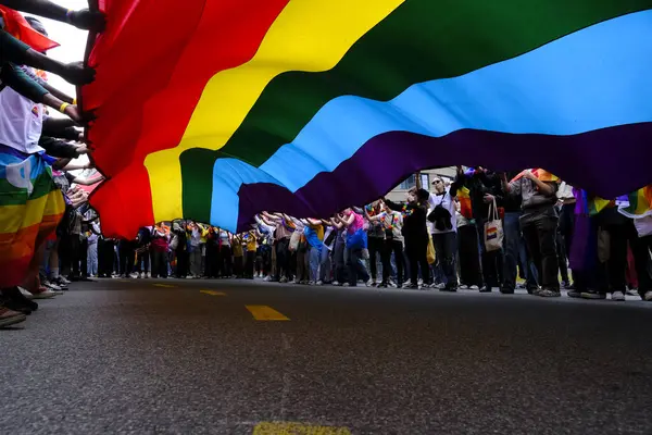 stock image People carry a large rainbow flag at the 'Belgian Pride', a manifestation of lesbian, gay, bisexual and transgender oriented people  in Brussels, Belgium on May 18, 2024.