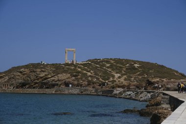 Yunanistan 'ın Naxos Adası' ndaki Delian Apollo antik tapınağının yıkıntıları önünde 3 Mayıs 2024 'te insanlar yürüyor.