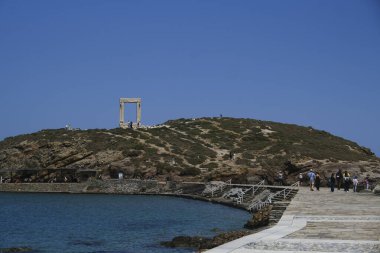 Yunanistan 'ın Naxos Adası' ndaki Delian Apollo antik tapınağının yıkıntıları önünde 3 Mayıs 2024 'te insanlar yürüyor.