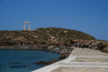 Yunanistan 'ın Naxos Adası' ndaki Delian Apollo antik tapınağının yıkıntıları önünde 3 Mayıs 2024 'te insanlar yürüyor.