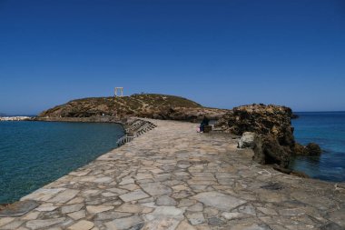 Yunanistan 'ın Naxos Adası' ndaki Delian Apollo antik tapınağının yıkıntıları önünde 3 Mayıs 2024 'te insanlar yürüyor.