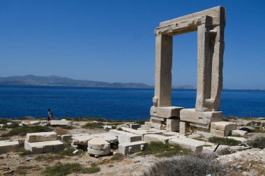 Yunanistan 'ın Naxos Adası' ndaki Delian Apollo antik tapınağının yıkıntıları önünde 3 Mayıs 2024 'te insanlar yürüyor.