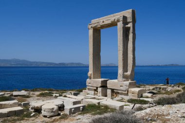 Yunanistan 'ın Naxos Adası' ndaki Delian Apollo antik tapınağının yıkıntıları önünde 3 Mayıs 2024 'te insanlar yürüyor.