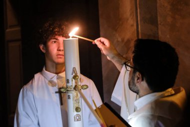 Papaz, Yunanistan 'ın Naxos Katedrali' nde 2 Mayıs 2024 'te düzenlenen Paskalya ayini sırasında Kutsal Ateşi kutsadı..