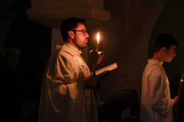 Papaz, Yunanistan 'ın Naxos Katedrali' nde 2 Mayıs 2024 'te düzenlenen Paskalya ayini sırasında Kutsal Ateşi kutsadı..