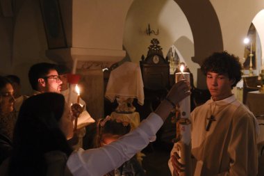 Katolik Hıristiyanlar, 4 Mayıs 2024 'te Yunanistan' ın Naxos katedralindeki Katolik Kilisesi 'nde düzenlenen Paskalya ayini sırasında mum tutarlar..