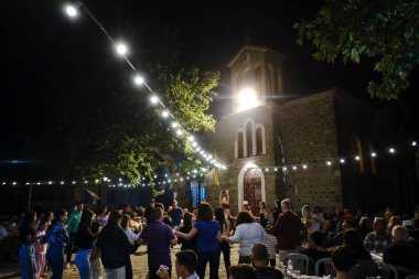 İnsanlar, 26 Temmuz 2024 'te Lefka veya Yunanistan' ın Paloukova köyünde düzenlenen festivalde geleneksel halk danslarında festivale katılıyor..