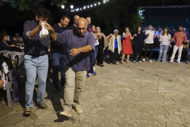 İnsanlar, 26 Temmuz 2024 'te Lefka veya Yunanistan' ın Paloukova köyünde düzenlenen festivalde geleneksel halk danslarında festivale katılıyor..