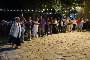 İnsanlar, 26 Temmuz 2024 'te Lefka veya Yunanistan' ın Paloukova köyünde düzenlenen festivalde geleneksel halk danslarında festivale katılıyor..