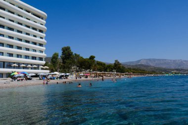 People enjoy the sea at in front of luxury hotel in Agioi Theodoroi beach, Peloponnese, Greece, on August 23, 2024. clipart