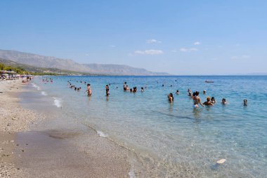 Yunanistan 'ın Moreloponnese kentindeki sıcak bir yaz gününde 23 Ağustos 2024' te Agioi Theodoroi plajında insanlar serinliyor..