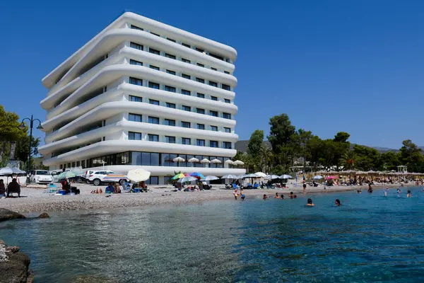 stock image People enjoy the sea at in front of luxury hotel in Agioi Theodoroi beach, Peloponnese, Greece, on August 23, 2024.