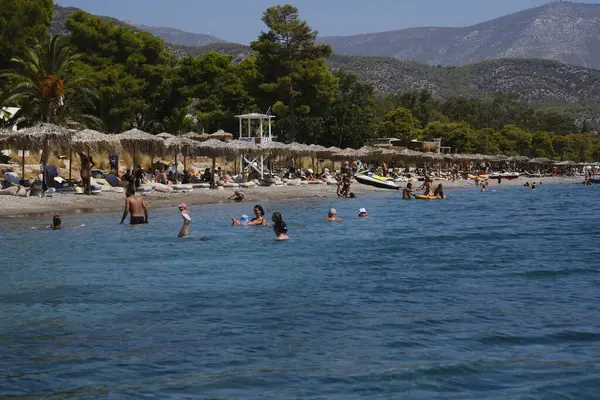 stock image People cool off at the  Agioi Theodoroi beach on a hot summer day in Peloponnese, Greece, on August 23, 2024.