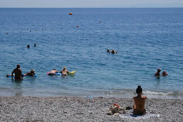 Yunanistan 'ın Moreloponnese kentindeki sıcak bir yaz gününde 23 Ağustos 2024' te Agioi Theodoroi plajında insanlar serinliyor..