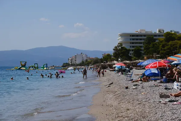 stock image People sunbathe during a sunny summer day in Agioi Theodoroi beach, Peloponnese, Greece, on August 23, 2024.