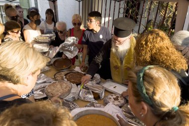 Yunanistan 'ın başkenti Atina' da 26 Ağustos 2024 'te düzenlenen dini törende bir rahip ekmeğe katılıyor ve onu kutsuyor..