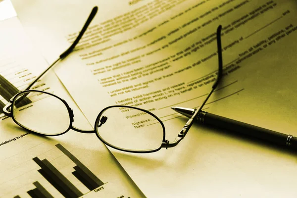 Business legal document concept : Pen and glasses on a agreement form.