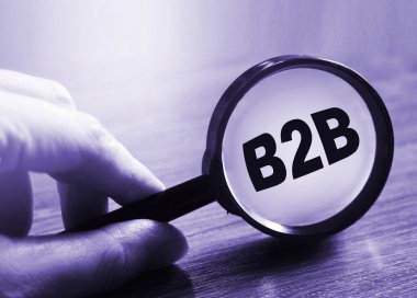 İş adamı elinde büyüteçle B2B kısaltması tutuyor. İş İş Konseptine.