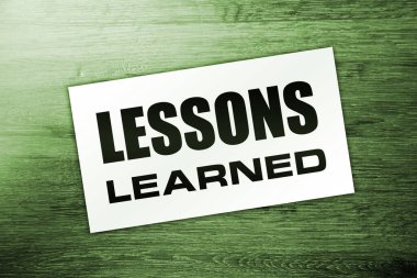 Ahşap arka planda öğrenilen mesajlarla dolu boş bir kart. İş konsepti.