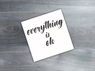 Ahşap yüzeyinde siyah harflerle beyaz yapışkan not. Her şey yazılı.